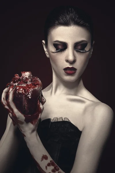 Beleza jovem ruiva mulher traz um coração humano — Fotografia de Stock