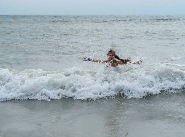 Uzun Saçlı Çizgili Mayo Giymiş Bir Kız Deniz Dalgalarına Doğru — Stok fotoğraf