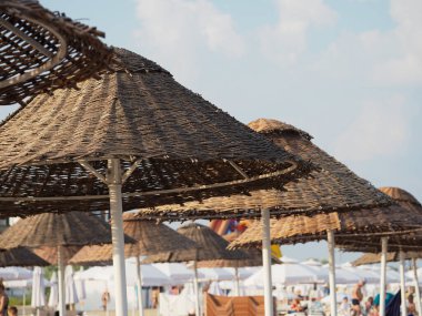 Gökyüzünün arka planında hasır olan plaj mantarı 