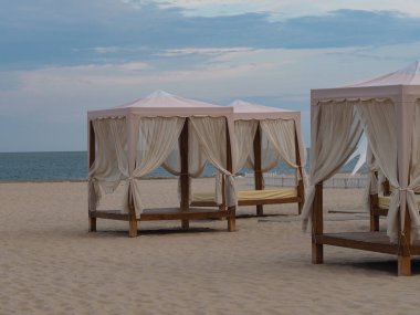 Kumsalda tenteli olan, kumlu bir plajda insanların olmadığı bir yer.