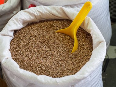 Pazar yerinde kavrulmuş karabuğday taneleri beyaz torbada.