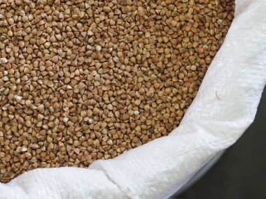 Pazar yerinde kavrulmuş karabuğday taneleri beyaz torbada.