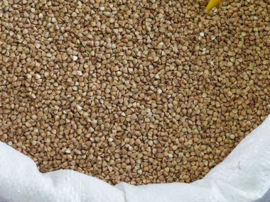 Pazar yerinde kavrulmuş karabuğday taneleri beyaz torbada.