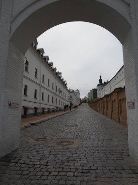 Beyazlatılmış kadim manastır duvarı üzerinde asfalt bir yol ile toprak bir duvar