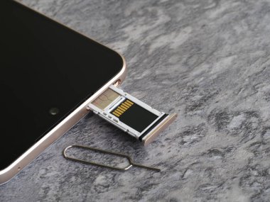 SIM kart ve mikro SD kart için yarı açık tepsisi olan akıllı telefon ve tepsiyi açmak için ataç