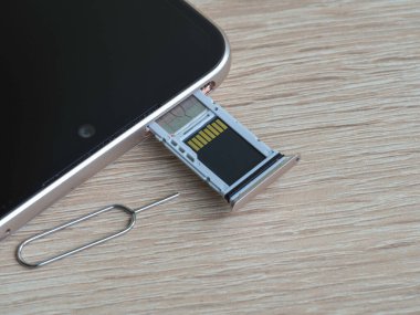 SIM kart ve mikro SD kart için yarı açık tepsisi olan akıllı telefon ve tepsiyi açmak için ataç