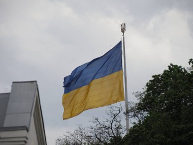 Bayrak direğindeki büyük Ukrayna bayrağı. Üzerinde devlet amblemi var. Üç dişli bir mızrak.