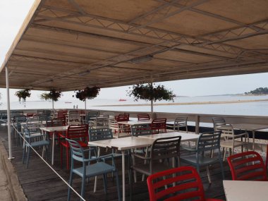 Interior of an outdoor cafe on the sea coast without people with plastic furniture