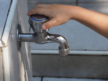 Close-up of a small water faucet for washing hands at a campsite on the seashore