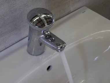 An open water tap from which water flows