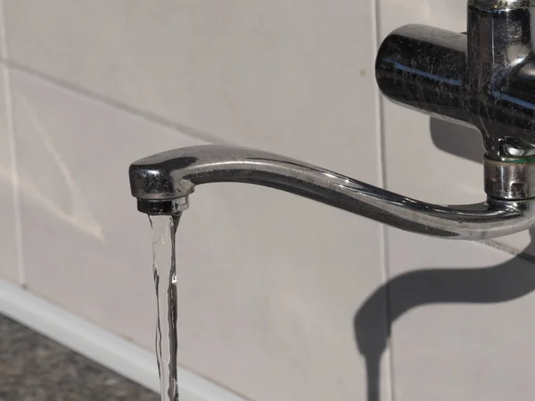 An open water tap from which water flows