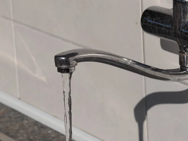 An open water tap from which water flows