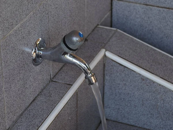 An open water tap from which water flows