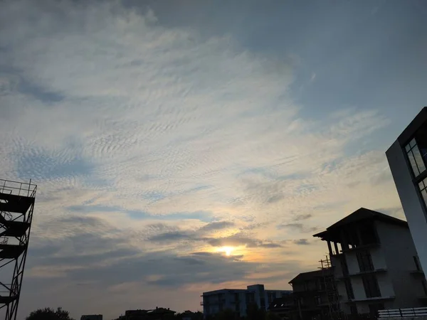 sunset with light gray clouds with glimpses of blue sky