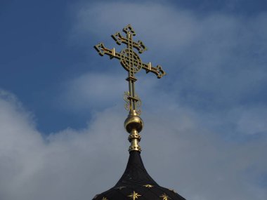 Gökyüzünün arka planında haç olan Ortodoks kilisesinin yaldızlı kubbesi