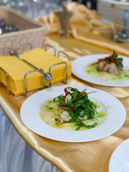 Beyaz tabakta patates püresi ve sebzeli balık.