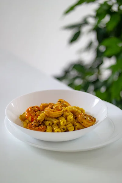 意大利面 虾仁和姜黄在白盘的白桌上 说明一个食谱 高质量的照片 — 图库照片