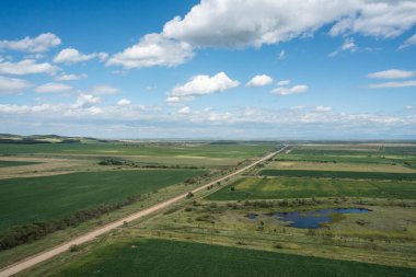 Uzağa uzanan tarlaların arasındaki köy yolu..