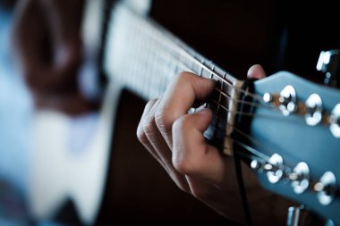 El gitar üzerinde ustaca çalıyor..