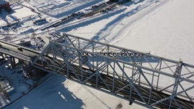 Arkhangelsk, Rusya - 11 Mart 2021 Kışın donmuş nehir boyunca demir köprünün en üst manzarası.