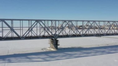 Arkhangelsk, Rusya - 11 Mart 2021 Kışın demir köprü ve donmuş nehir boyunca bir şehir manzarası.