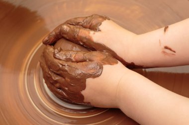 Çocuk çömlekçinin tekerindeki çömlek kalıbından şekilleniyor.. 