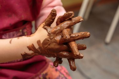 Çocukların elleri kille kaplıdır..