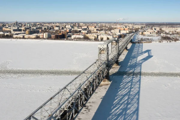 ロシア アルカンゲルスク 2021年3月11日凍結した川を流れる鉄の橋と都市の冬のトップビュー — ストック写真