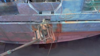 Slavianka, Primorsky Kray, Rusya - 10 Mayıs 2020: İşçi kum püskürtücü bir gemi tahtasını işliyor.