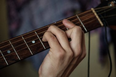 El gitar üzerinde ustaca çalıyor..