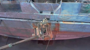 Slavianka, Primorsky Kray, Rusya - 10 Mayıs 2020: İşçi kum püskürtücü bir gemi tahtasını işliyor.