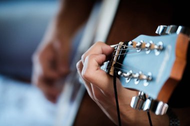 El gitar üzerinde ustaca çalıyor..