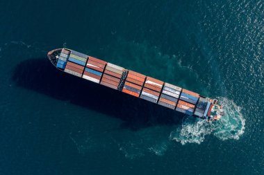 Deniz konteynırı gemisi denizde hareket ediyor. Çivinin çıkardığı köpüğün etrafında. Yukarıdan geminin görüntüsü.