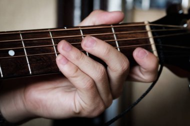 El gitar üzerinde ustaca çalıyor..