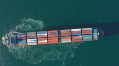 Deniz konteynırı gemisi denizde hareket ediyor. Çivinin çıkardığı köpüğün etrafında. Yukarıdan geminin görüntüsü.