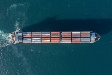 Deniz konteynırı gemisi denizde hareket ediyor. Çivinin çıkardığı köpüğün etrafında. Yukarıdan geminin görüntüsü.