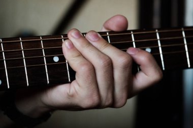 El gitar üzerinde ustaca çalıyor..