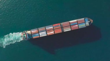Deniz konteynırı gemisi denizde hareket ediyor. Çivinin çıkardığı köpüğün etrafında. Yukarıdan geminin görüntüsü.