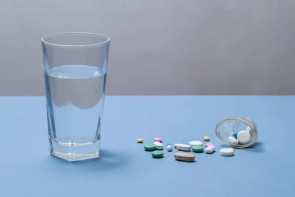 蓝色底色的一杯水和药物. — 图库照片
