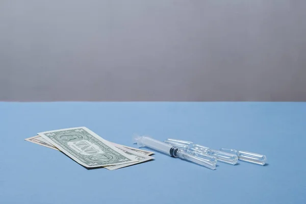 Money, a syringe and ampoules are on the table. — 스톡 사진