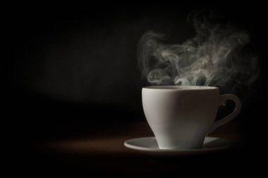 Çay fincanından koyu bir arka planda buhar çıkıyor..
