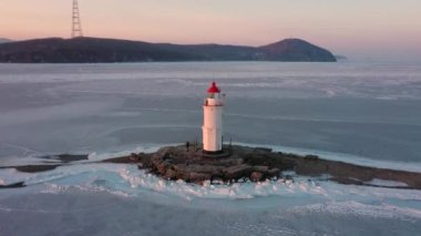 Taşın üzerindeki deniz feneri Tokarevskaya Koshka 'yı kışın Rusya' nın Vladivostok kentinde tükürüyor. Üst görünüm