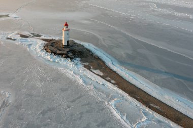 Taşın üzerindeki deniz feneri Tokarevskaya Koshka 'yı kışın Rusya' nın Vladivostok kentinde tükürüyor. Üst görünüm