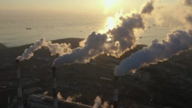 Dumanla dalgalanan bacaları olan çalışan bir fabrika..