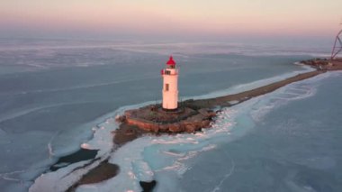 Taşın üzerindeki deniz feneri Tokarevskaya Koshka 'yı kışın Rusya' nın Vladivostok kentinde tükürüyor. Üst görünüm