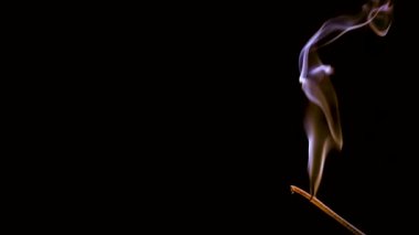 Aroma çubuğu yanar ve sigara içer. Renkli duman yavaş çekimde ve yakın çekimde çekilir..