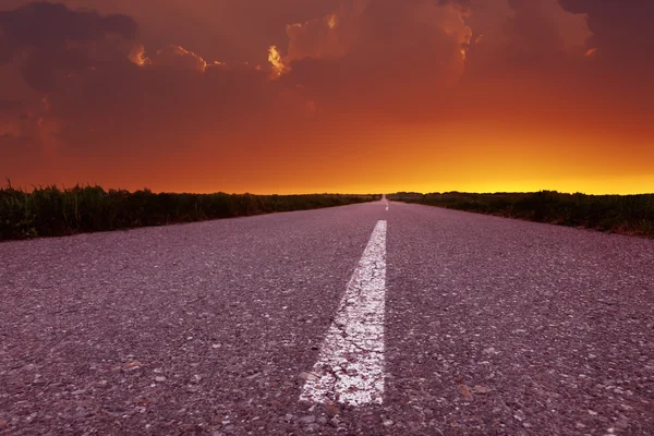 Conduire sur une route vide au beau coucher du soleil — Photo