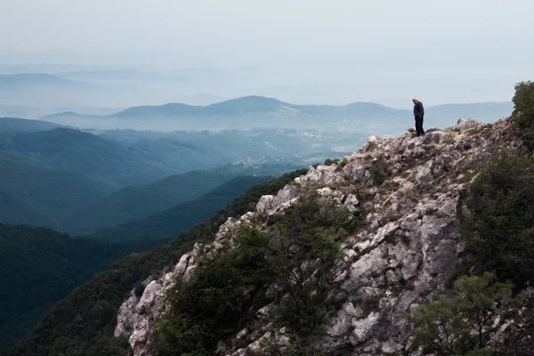 Elderly man standing on the edge of the cliff