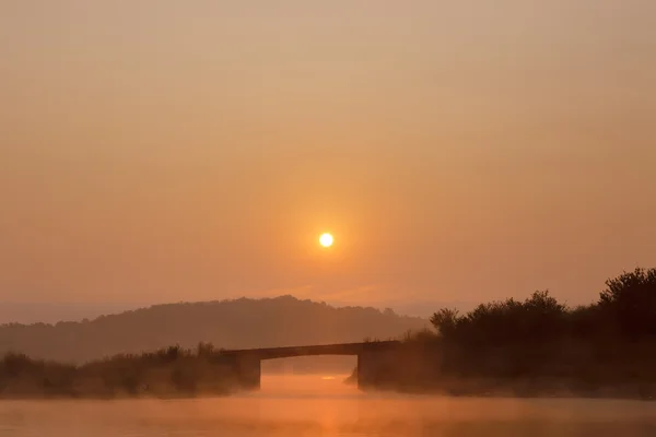Ponte no nevoeiro da manhã ao nascer do sol — Fotografia de Stock