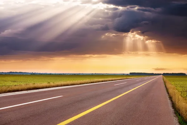 Auf leerer Autobahn gegen die Sonnenstrahlen fahren — Stockfoto